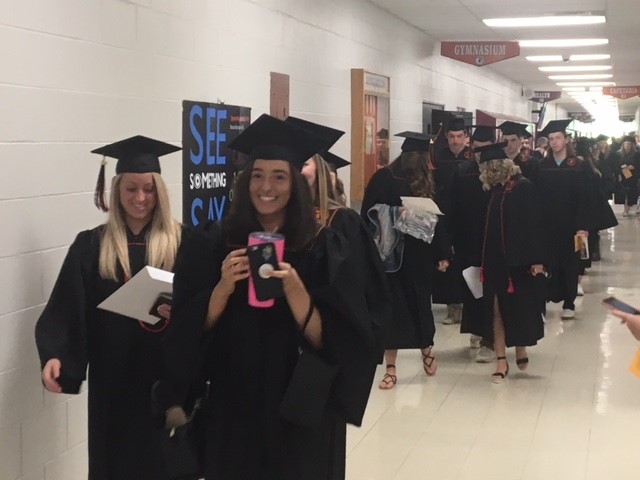 graduates walking through a hallway